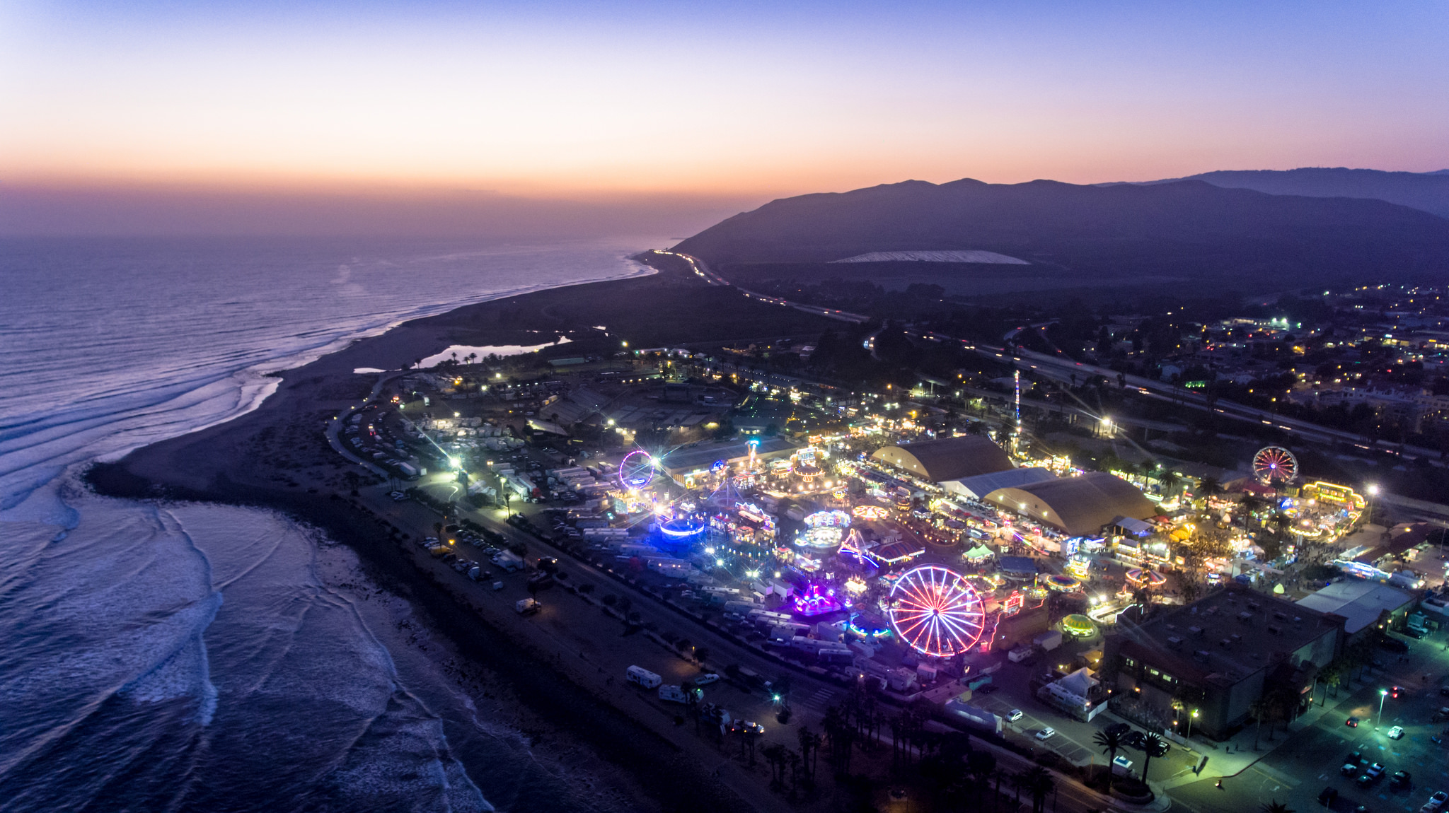 Areal vantage point of the Ventura County fair at dusk, presenting coastline and lit up excitement of the Fair during the early evening.